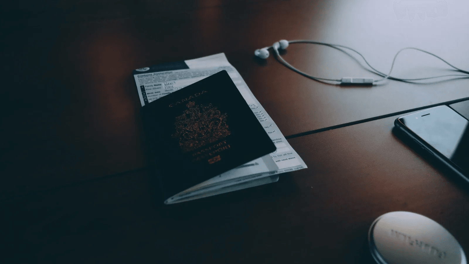 Passport, client documents, phone, and headphones on a dark desk for secure lawyer-client messaging.